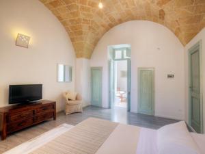 1 dormitorio con 1 cama y TV en una mesa en Miro B&B en Lecce