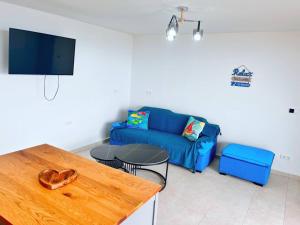 WillibrordusにあるNEU!!! Apartment im Luxory Resort Coral Estateのリビングルーム(青いソファ、テーブル付)