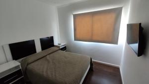 Dormitorio pequeño con cama y TV en Tu lugar en Villa en Villa Constitución