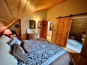 a bedroom with a large bed and a wooden door at Moss Mountain Inn in Columbia Falls