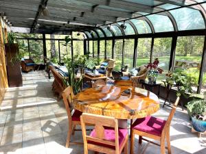 a patio with a table and chairs in a greenhouse at Moss Mountain Inn in Columbia Falls