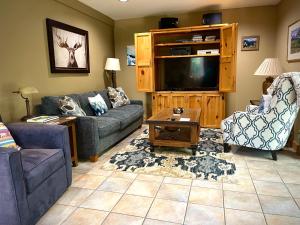 a living room with two couches and a flat screen tv at Moss Mountain Inn in Columbia Falls