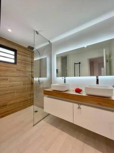 a bathroom with two sinks and a mirror at Condo Airport Tahiti Faa'a in Faaa