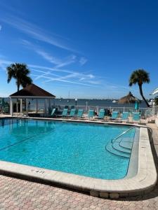 a swimming pool with chairs and the ocean in the background at Two-Bedroom Apartment in St. Petersburg