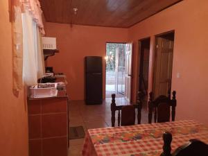 a kitchen with a table and a refrigerator in a room at Casa del Eucalipto in Sabana Redonda