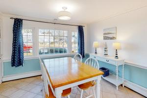 comedor con mesa, sillas y ventana en Captain's Hidden Treasure, en South Yarmouth