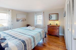 1 dormitorio con 1 cama, vestidor y 2 ventanas en Captain's Hidden Treasure, en South Yarmouth