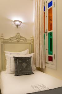 una camera con un letto bianco e una finestra di HOTEL RIAD CHAMI a Marrakech