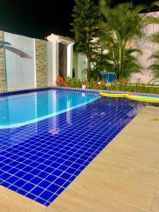 a swimming pool with blue tiles on the ground at Recanto ViVa - Catuama in Goiana