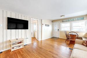 ein Wohnzimmer mit einem Sofa und einem Flachbild-TV in der Unterkunft Cool Change in Hampton