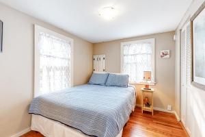 ein Schlafzimmer mit einem Bett und zwei Fenstern in der Unterkunft Cool Change in Hampton