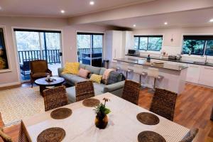 Warrandyte的住宿－Resort-style 4 bdrm home w pool, spa & billiards!，厨房以及带沙发和桌子的客厅。