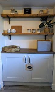 une cuisine avec des placards blancs et un comptoir dans l'établissement Parkview Cottage - Lovely home overlooking park, à Carnoustie