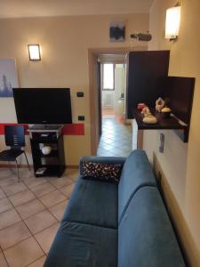uma sala de estar com um sofá azul e uma televisão em Residenza tra Parma e Fiere em Baganzola
