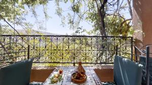 un tavolo con sedie e un balcone con vista. di Auberge Ayam Atlas a Ourika