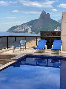una piscina con sillas y vistas al océano en Flat Vieira Souto Vista Mar, en Río de Janeiro