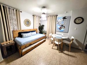 um quarto com uma cama e uma mesa com cadeiras em Bee Inn Puerto Rico Charming Urban Apartment in San Juan em San Juan