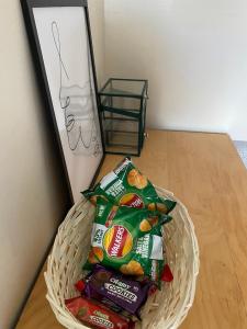 a basket filled with bags of chips and other snacks at Cosy Room in Bristol in Bristol