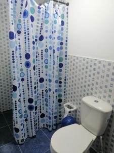 a bathroom with a toilet and a shower curtain at CASA HOTEL QR in Cali