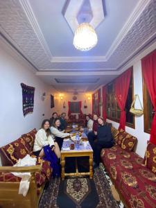 un groupe de personnes assises dans un salon dans l'établissement Amazigh Family Riad, à Imlil