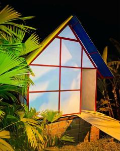 una pequeña casa con techo azul y rojo en El eden en Manizales