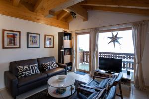 a living room with a couch and a tv at Camelot 5 in Bettmeralp +20 photos
