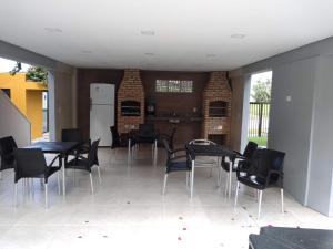 a room with tables and chairs and a kitchen at Condomínio Reserva dos Corais in Cabo de Santo Agostinho