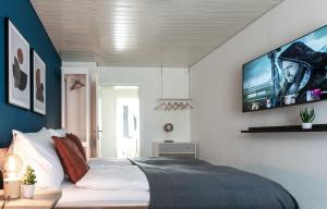 Spirit Apartments Zentral mit gratis Parkplatz في لوتزيرن: غرفة نوم مع سرير وتلفزيون على الحائط