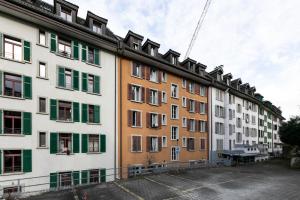 Spirit Apartments Zentral mit gratis Parkplatz في لوتزيرن: صف من المباني ذات اللون الأخضر والأبيض