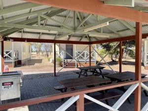 einen Picknickplatz mit zwei Picknicktischen und einem Mülleimer in der Unterkunft BIG4 Port Willunga Tourist Park in Aldinga