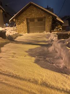 una entrada cubierta de nieve frente a un garaje en Apratmani Ivić, en Kupres