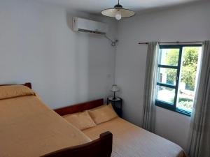 1 dormitorio con cama y ventana en Castillo Del Lago - Carlos Paz - D24 en Villa Carlos Paz