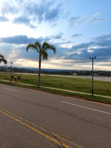 two people sitting on the side of a road with a palm tree at Castillo Del Lago - Carlos Paz - D24 in Villa Carlos Paz