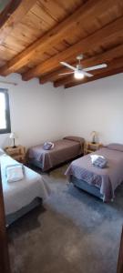 Zimmer mit 3 Betten und einer Decke in der Unterkunft Casa Isolina in Ciudad Lujan de Cuyo
