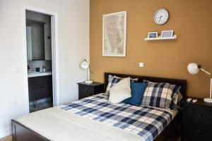 a bedroom with a bed and a clock on the wall at The Parthenon Terrace ReNoVaTeD with a view ! in Athens
