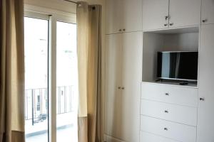 a white cabinet with a tv and a window at The Parthenon Terrace ReNoVaTeD with a view ! in Athens