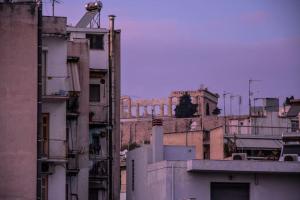 a group of buildings with a clock on top of them at The Parthenon Terrace ReNoVaTeD with a view ! in Athens