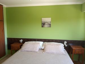 1 dormitorio con 1 cama con pared verde en Edificio Acuario II en Villa Carlos Paz