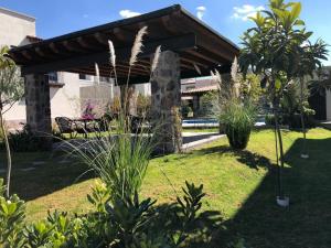 un pavillon dans un jardin avec pelouse et plantes dans l'établissement Small pet friendly, Pool and Gym Apartment, à San Miguel de Allende