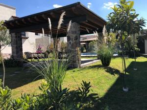 a pavilion in a garden with grass and plants at Small pet friendly, Pool and Gym Apartment in San Miguel de Allende
