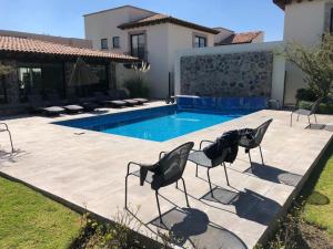 a patio with chairs and a swimming pool at Small pet friendly, Pool and Gym Apartment in San Miguel de Allende