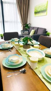 a wooden table with plates and dishes on it at The Icon 3 Condo in IOI City Mall Putrajaya, Pool View in Putrajaya