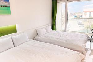 Postel nebo postele na pokoji v ubytování Hamdeok Beach Stay Jeju