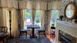 ein Esszimmer mit Tisch und Stühlen sowie einem Kamin in der Unterkunft Bedham Hall B&B in Niagara Falls