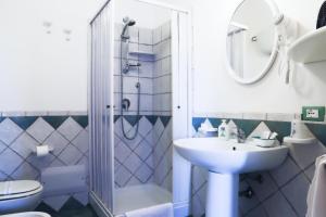 uma casa de banho com um lavatório, um chuveiro e um WC. em Villa dei giardini em San Leone