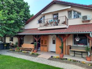 a house with a porch and a bench in the yard at Sissy Vendégház in Mórahalom