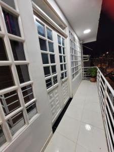 un pasillo de un edificio con puertas y ventanas blancas en Apartaestudios El Descanso, en Cali