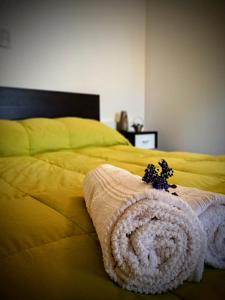 a bedroom with a yellow bed with a towel on it at Departamento Urbano in San Carlos de Bariloche