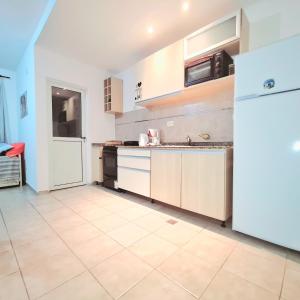 een keuken met een witte koelkast en een tegelvloer bij departamentos corrientes in Corrientes