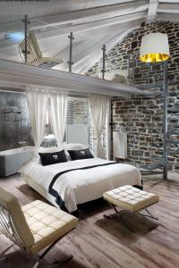 a bedroom with a large bed and a brick wall at Mikro Papigo 1700 Hotel & Spa in Papigko